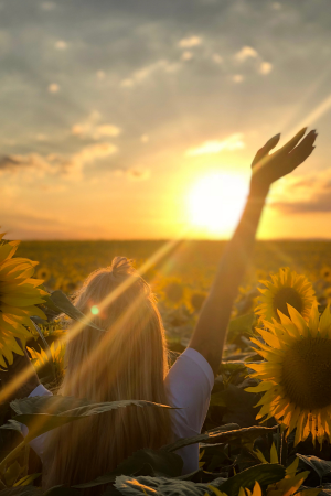 woman praising God in sunflower field