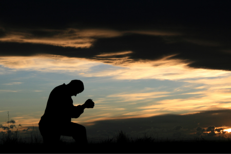 man praying in a field