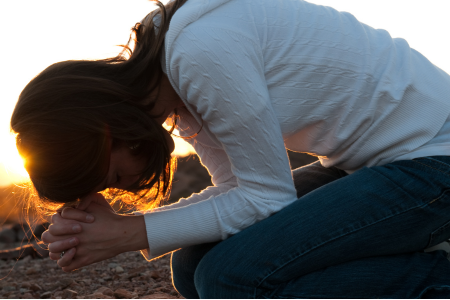 woman kneeling down in prayer