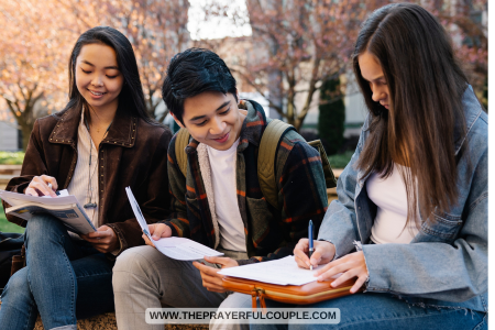 young man and 2 young women studying in park
