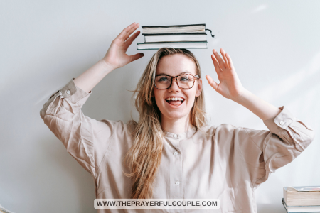 woman with 3 books on her head smiling
