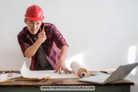 contractor in hard hat reading building plans