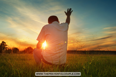man kneeling and praying in field